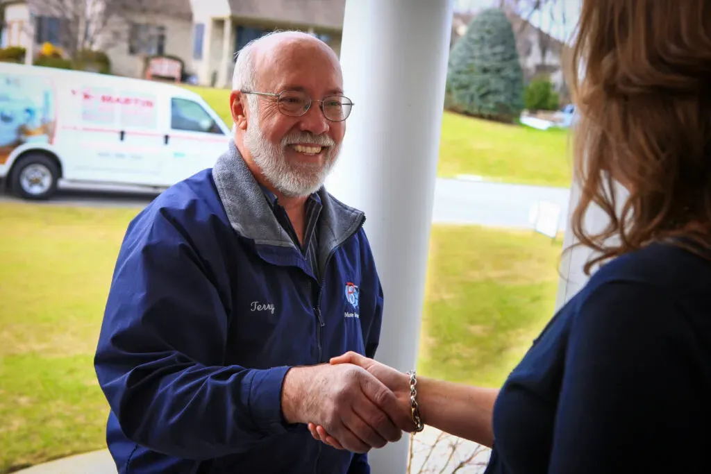 Service guy shaking woman's hand on the front porch